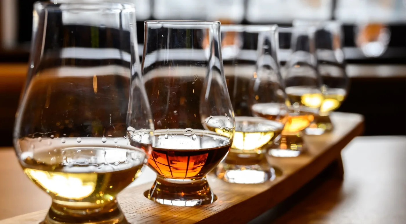 A flight of Irish whiskey in Glencairn nosing glasses on a wooden paddle